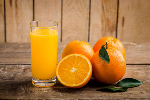 istock Orange juice with orange and green leaf on wooden table 1093574982