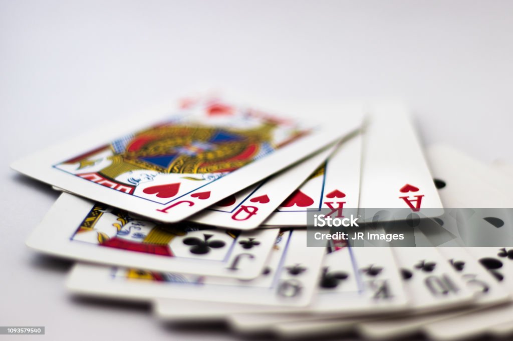 Playing Cards fanned out: Suit of Spades, Clubs and Diamonds fanned out over white background. Gambling, Poker, Win, Lose, Chance, Gambling, Money, Red, Black, Jack, Queen, King Playing cards with banknotes and coins for gambling Playing Card Stock Photo