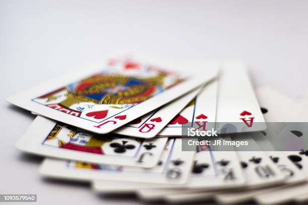Playing Cards Fanned Out Suit Of Spades Clubs And Diamonds Fanned Out Over White Background Gambling Poker Win Lose Chance Gambling Money Red Black Jack Queen King Stock Photo - Download Image Now