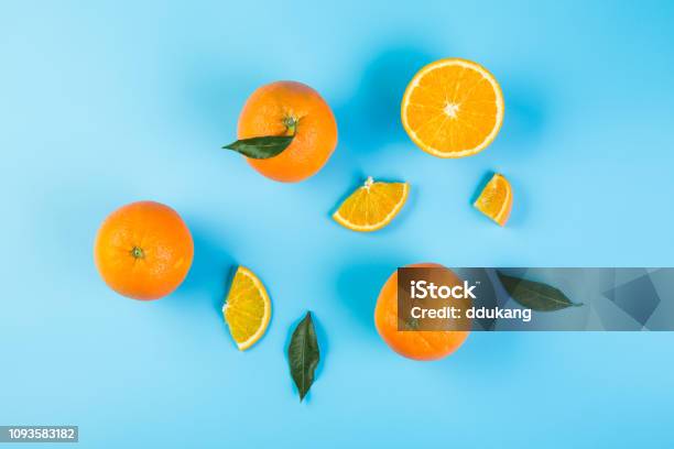 Healthy Food Sliced Orange With Green Leaves On Blue Background Top View Stock Photo - Download Image Now