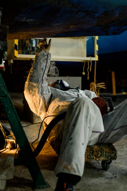 istock Man using grinding machine, maintenance of sailing yacht in boathouse 1093586348