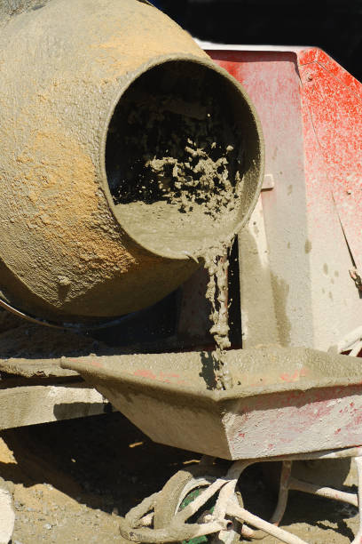 istock Pouring fresh concrete from electrical mixer into wheelbarrow 1093590596