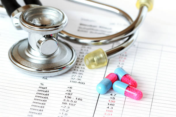 istock Stethoscope and pills on a check-up result report, on which abnormal values are showing in warning red color 1093593130