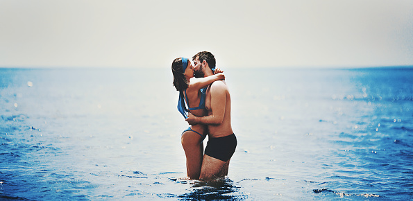 Young couple kissing and hugging in the sea.