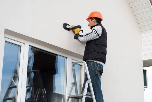 istock electrician mounts a wall lamp 1093593420