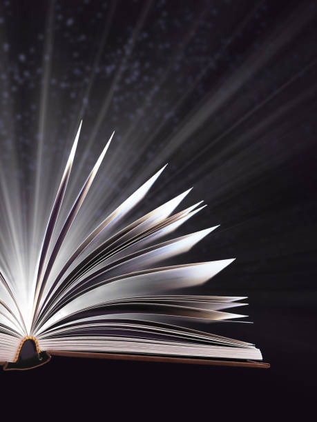 istock Part of open magic book, bewitched book glows in the darkness, magic light. Education. Dreamy image of a fairytale 1093598322