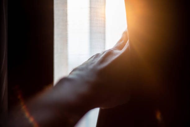istock Hand opening curtains in the bedroom with sun light background 1093599632