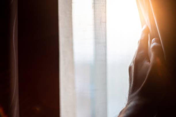 istock Hand opening curtains in the bedroom with sun light background 1093599634