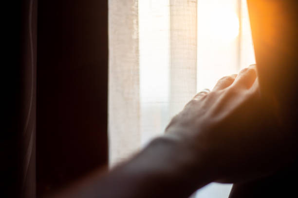 istock Hand opening curtains in the bedroom with sun light background 1093599642