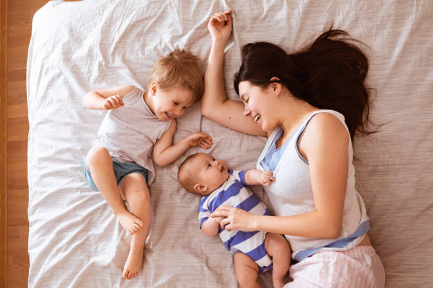 garçons de deux enfants s’embrassant leur mère. portrait de famille souriante heureuse de deux gros plan - famille avec deux enfants photos et images de collection