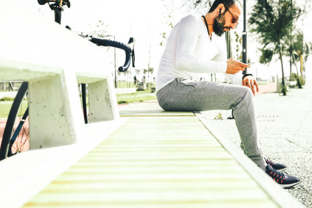 istock Mid Adult Man With Mobile Phone Resting in Park 1093605010