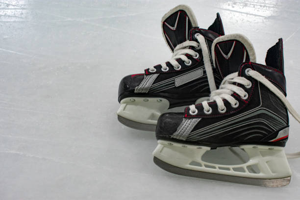 istock Hockey skates lying over ice rink with copy space 1093605714