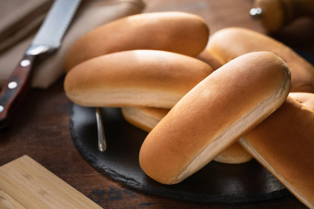 fresh hot dog buns on a wooden surface - pão doce imagens e fotografias de stock