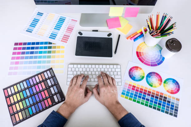 istock Image of male creative graphic designer working on color selection and drawing on graphics tablet at workplace with work tools and accessories, top view workspace 1093608822