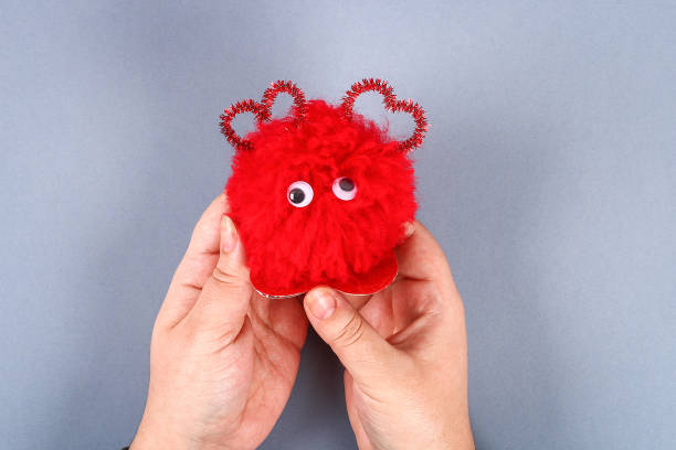 istock Red handmade diy monster pom pom from yarn, chenille stems in shape heart. 1093610564
