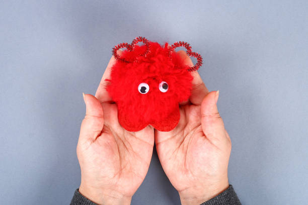 istock Red handmade diy monster pom pom from yarn, chenille stems in shape heart. 1093610568