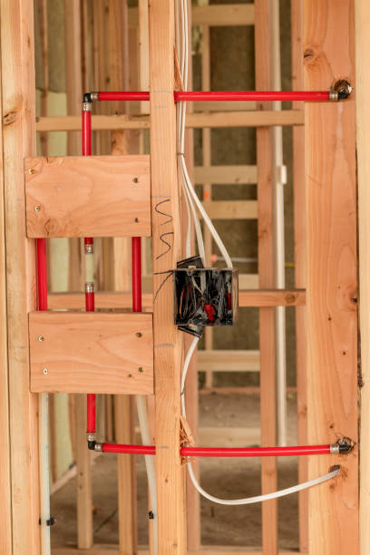 istock Rough wired electrical box near some modern plumbing red pipes 1093616780