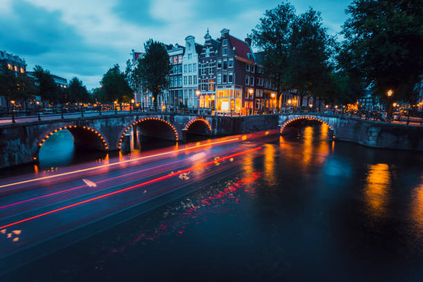 senderos de luz increíbles y reflexiones sobre el agua en el canal leidsegracht y keizersgracht en amsterdam por la noche. tiros largos de la exposición. concepto de viaje romántico - keizersgracht fotografías e imágenes de stock