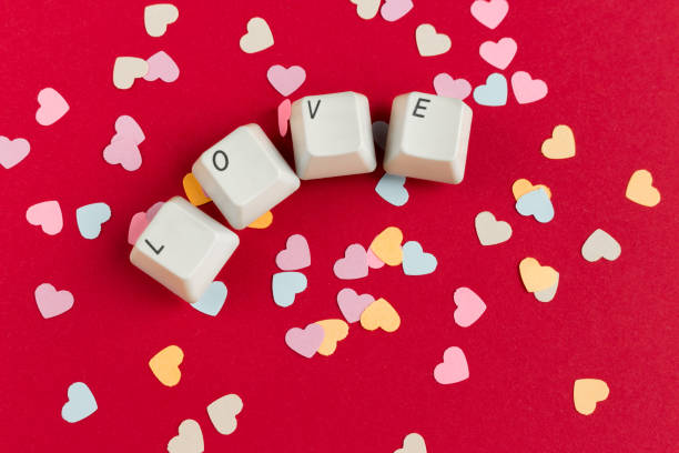 istock Computer keyboard keys with love word written using the white buttons with paper heart shaped confetti on red background. Valentine's card. Holiday concept. 1093624060