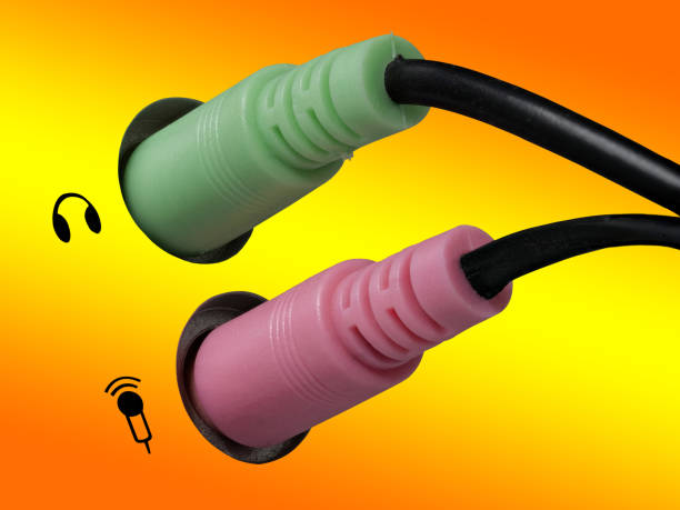 istock 0634 Plug for headphones, headsets and microphone on a computer, orange, yellow background, left side 1093624264