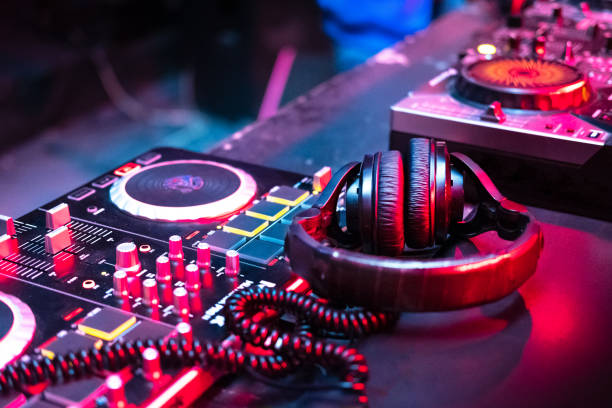 DJ music console in bright colors of light in night club DJ music console in bright colors of light in night club bright background dj stock pictures, royalty-free photos & images