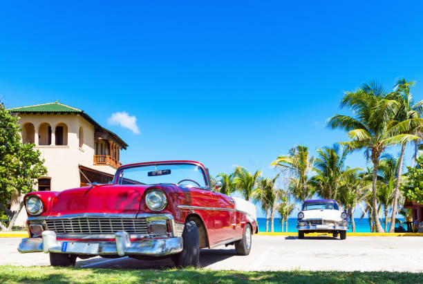 American red convertible and a blue white classic car parked on the beach in Varadero Cuba - Serie Cuba Reportage stock photo
