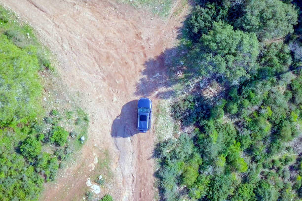 istock Off-Road Vehicle on a green forest road - Top down aerial image 1093640052
