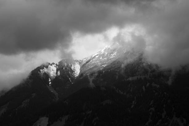 Snowcapped mountains in Austria Monochrome image, snowcapped mountain peak shrouded in clouds in Austria. ehrwald stock pictures, royalty-free photos & images