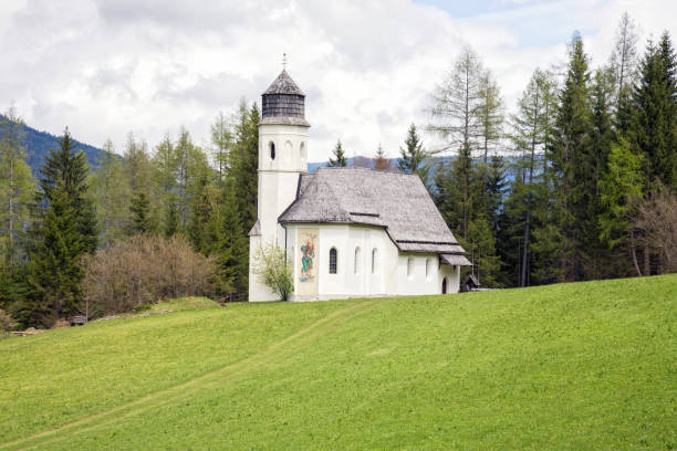 istock Alp meadow white church in Austria 1093643836