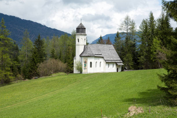 istock Alp meadow white church in Austria 1093643864