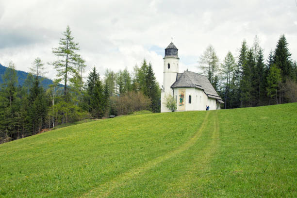 istock Alp meadow white church in Austria 1093643968