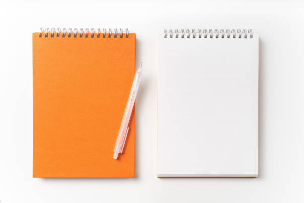istock Top view of orange spiral notebook, page, pencil 1093644402