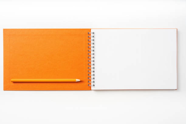 istock Top view of orange spiral notebook, page, pencil 1093645414