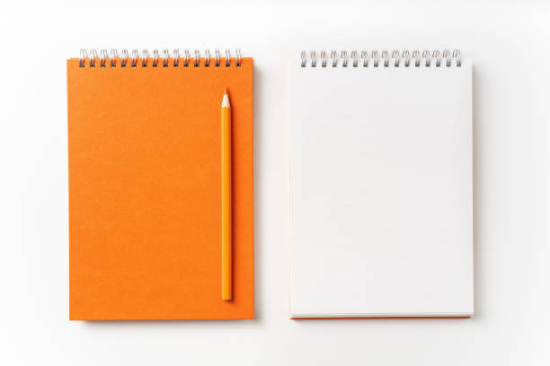 istock Top view of orange spiral notebook, page, pencil 1093645616