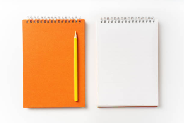 istock Top view of orange spiral notebook, page, pencil 1093645674