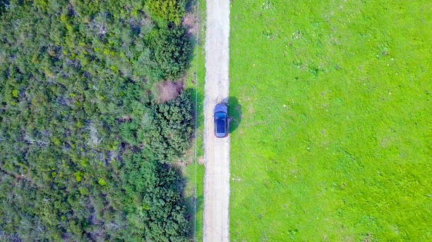 istock Off-Road Vehicle on a green forest road - Top down aerial image 1093645842