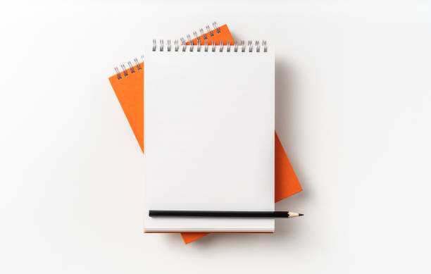 istock Top view of orange spiral notebook, page, pencil 1093647036