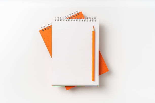 istock Top view of orange spiral notebook, page, pencil 1093647134