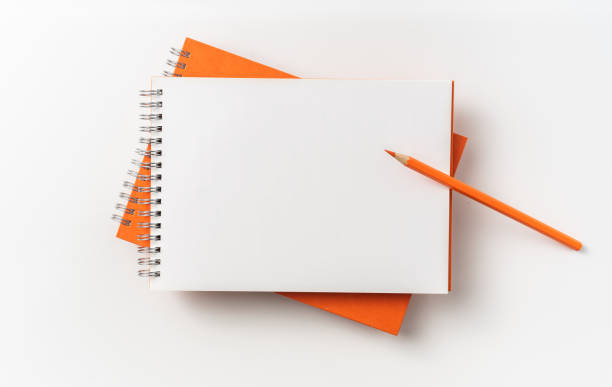 istock Top view of orange spiral notebook, page, pencil 1093647154