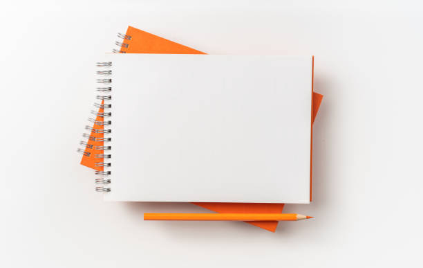 istock Top view of orange spiral notebook, page, pencil 1093647192
