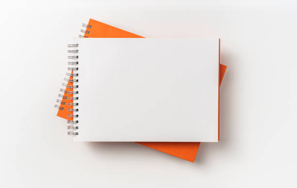 istock Top view of orange spiral notebook, page, pencil 1093647230
