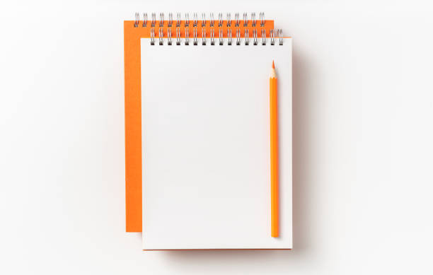 istock Top view of orange spiral notebook, page, pencil 1093647486