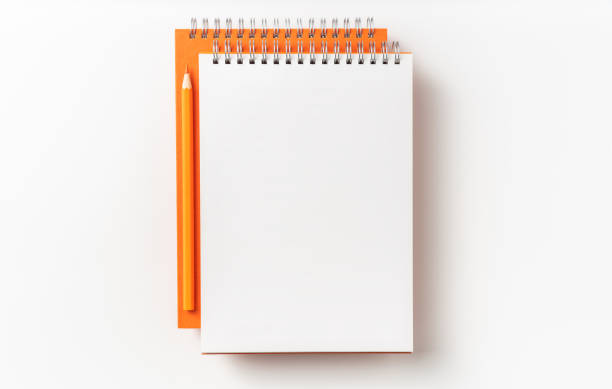 istock Top view of orange spiral notebook, page, pencil 1093647600