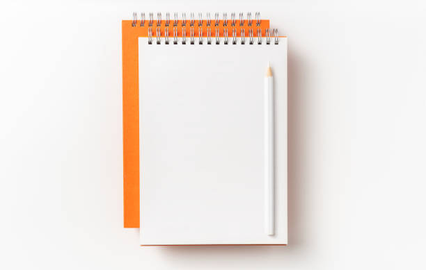 istock Top view of orange spiral notebook, page, pencil 1093647642