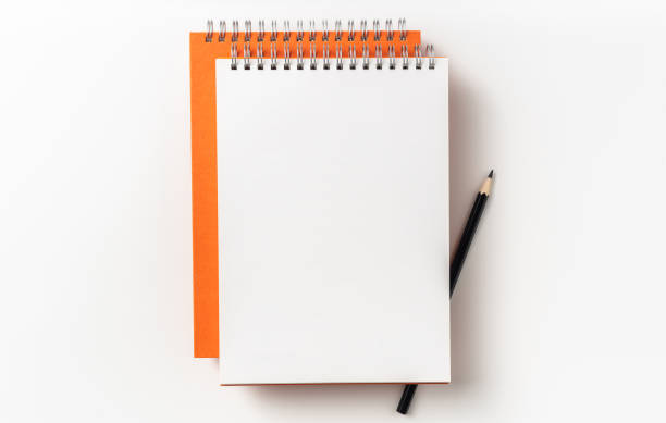 istock Top view of orange spiral notebook, page, pencil 1093647686