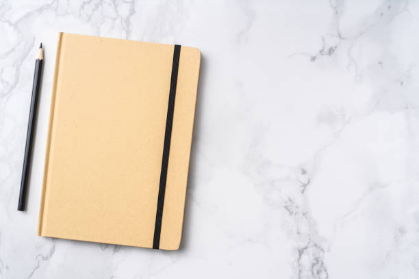 istock Top view of kraft paper notebook, pencil 1093661636