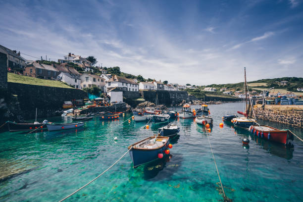 The Harbour and Fishing Village of Coverack in Cornwall, UK Coverack, Cornwall, UK - July 23, 2018.  A landscape view of the picturesque harbour full of small fishing boats in the idyllic holiday destination of Coverack in Cornwall, UK fishing village photos stock pictures, royalty-free photos & images