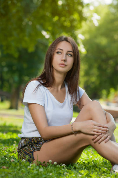 istock Charming Student Girl Sitting on Green Grass 1093664904