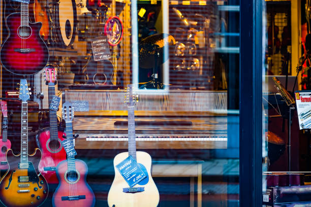 Music store Waalwijk, Netherlands - januari 8, 2019: the shopwindow of a music store with different musical instruments. Guitars, drums and a piano. berkel stock pictures, royalty-free photos & images
