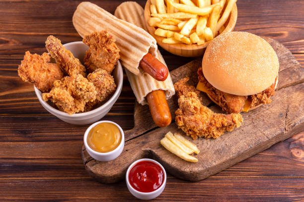 delicious but unhealthy food with ketchup and mustard on vintage cutting board - trans fats imagens e fotografias de stock